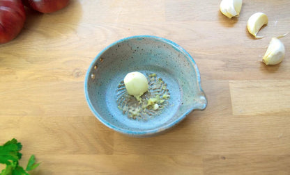 Greenish blue garlic grater plate with herb stripper and spout in matte speckled finish