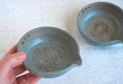 Greenish blue garlic grater plate with herb stripper and spout in matte speckled finish