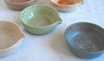 Greenish blue garlic grater plate with herb stripper and spout in matte speckled finish