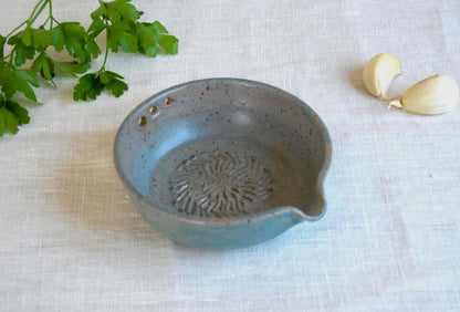 Greenish blue garlic grater plate with herb stripper and spout in matte speckled finish