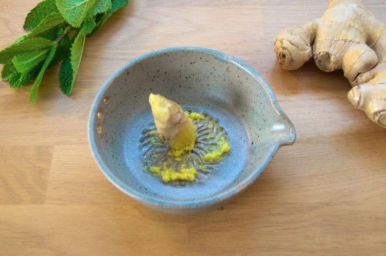 Greenish blue garlic grater plate with herb stripper and spout in matte speckled finish